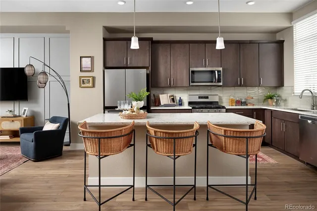 a kitchen with a table chairs refrigerator and microwave