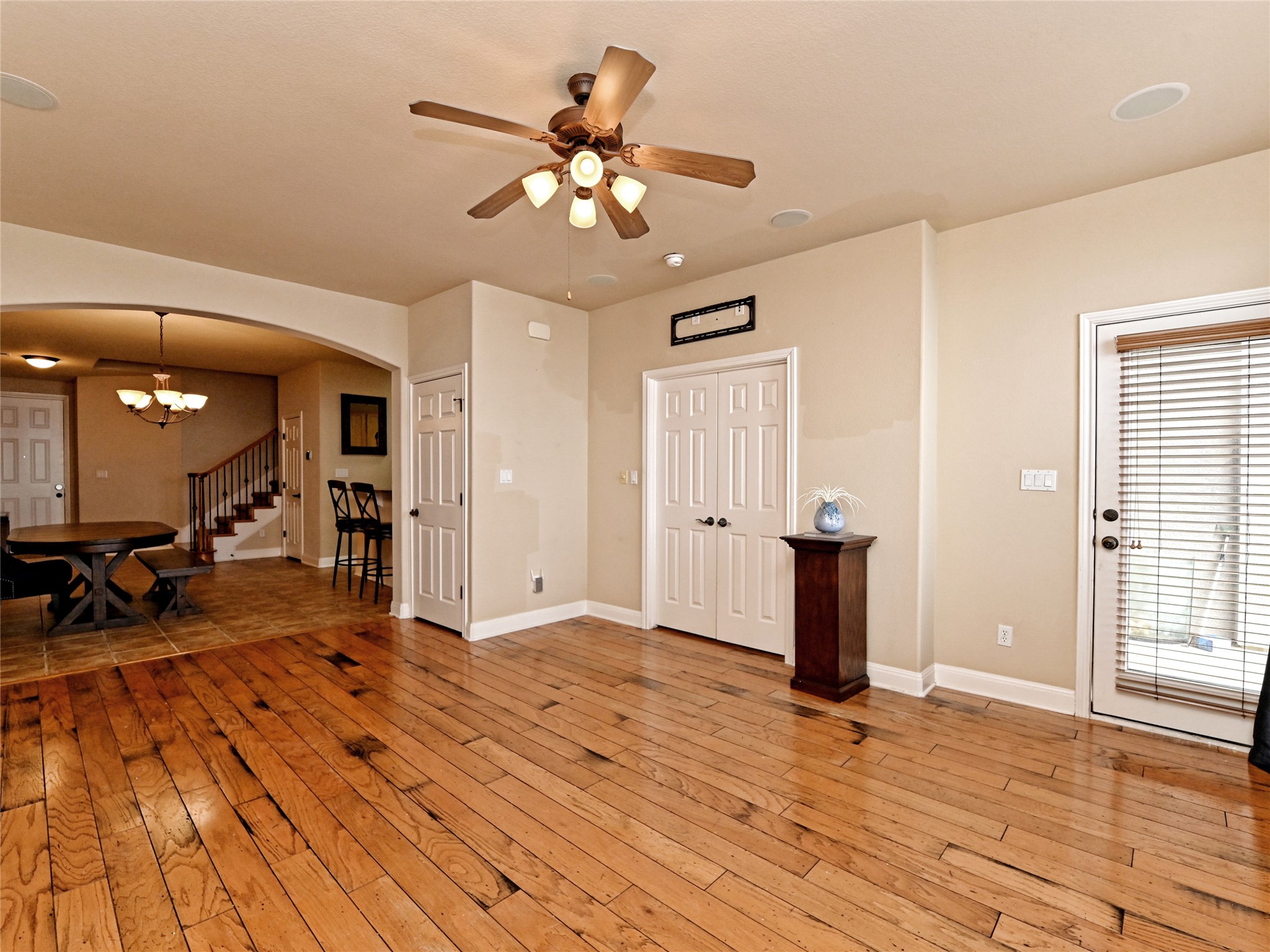 230 Sunrise Ridge Loop Austin, TX 78738 - Photo 5 of 27 Authentic wood flooring extends through an open-concept living area with a ceiling fan and ample natural light.
