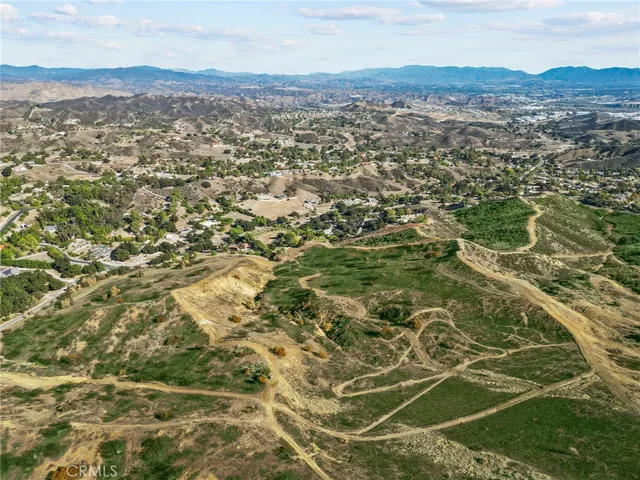 an aerial view of residential houses with outdoor space and trees
