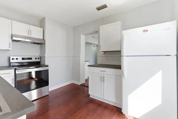 a kitchen with a refrigerator and a stove top oven