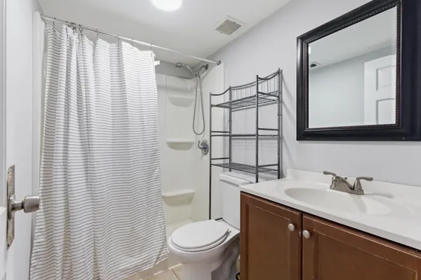 a bathroom with a granite countertop sink toilet and mirror