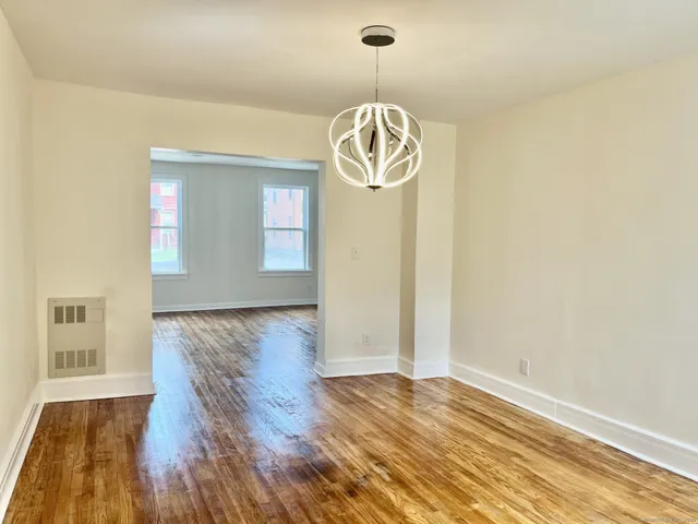 a view of empty room with wooden floor and window