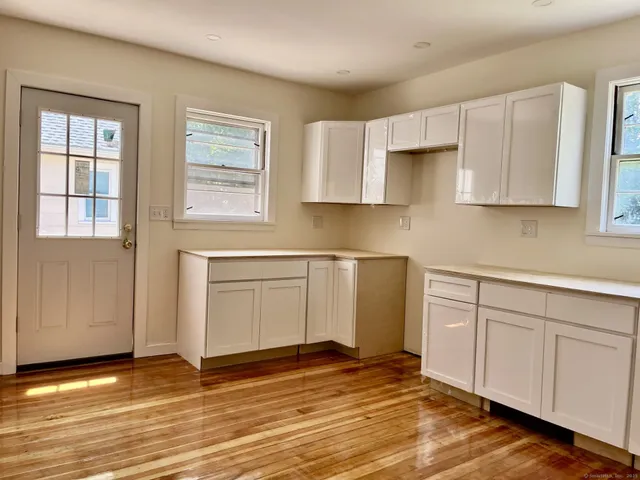 a kitchen with granite countertop white cabinets and sink