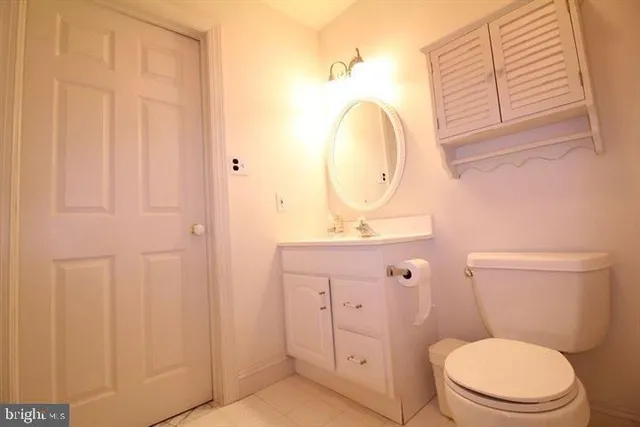 a bathroom with a toilet a sink a mirror a vanity and window