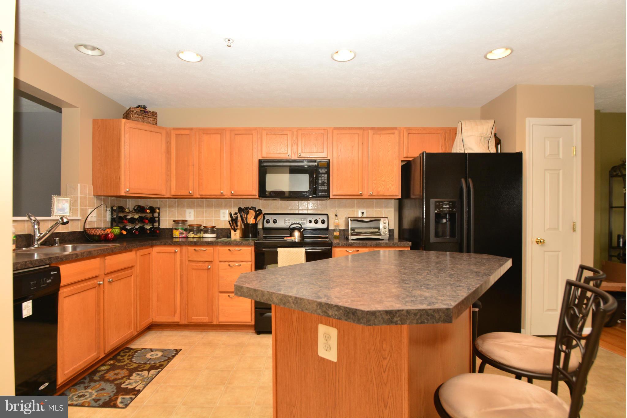 9705 Selfridge Road Baltimore, MD 21220 - Photo 6 of 30 a kitchen with stainless steel appliances granite countertop a sink a stove a refrigerator cabinets and a dining table