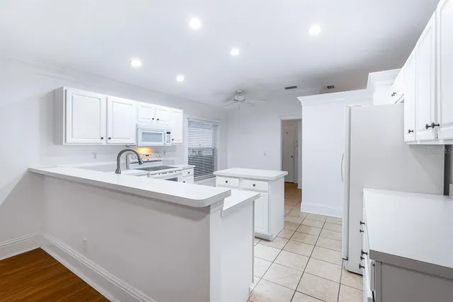 a kitchen with white cabinets and white appliances