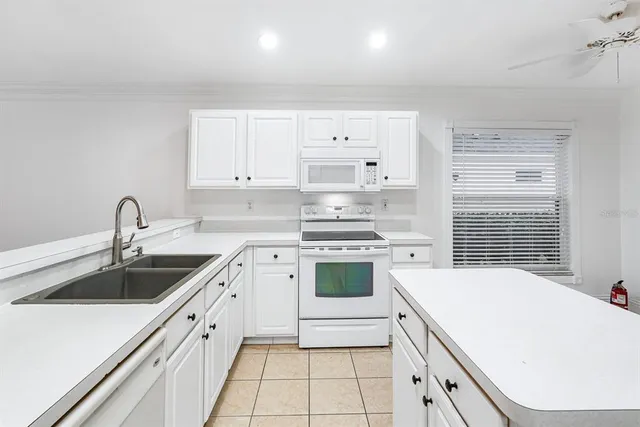a kitchen with white cabinets and refrigerator
