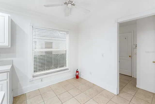 an empty room with wooden floor ceiling fan and windows