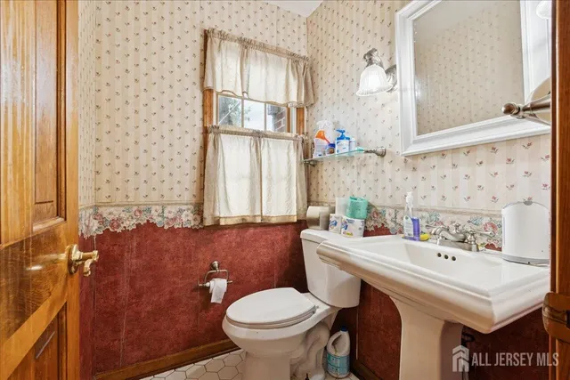 a bathroom with a sink a toilet and a mirror