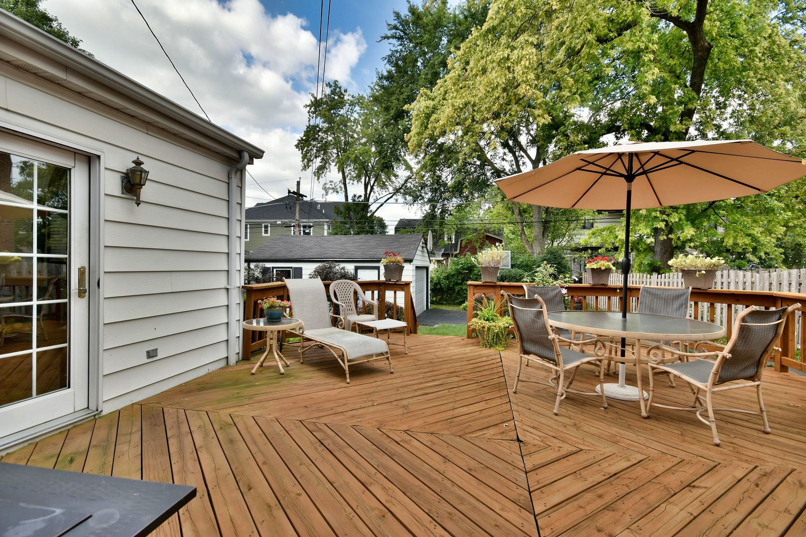 196 Fairfield Avenue Elmhurst, IL 60126 - Photo 43 of 44 a view of a roof deck with table and chairs under an umbrella with wooden floor