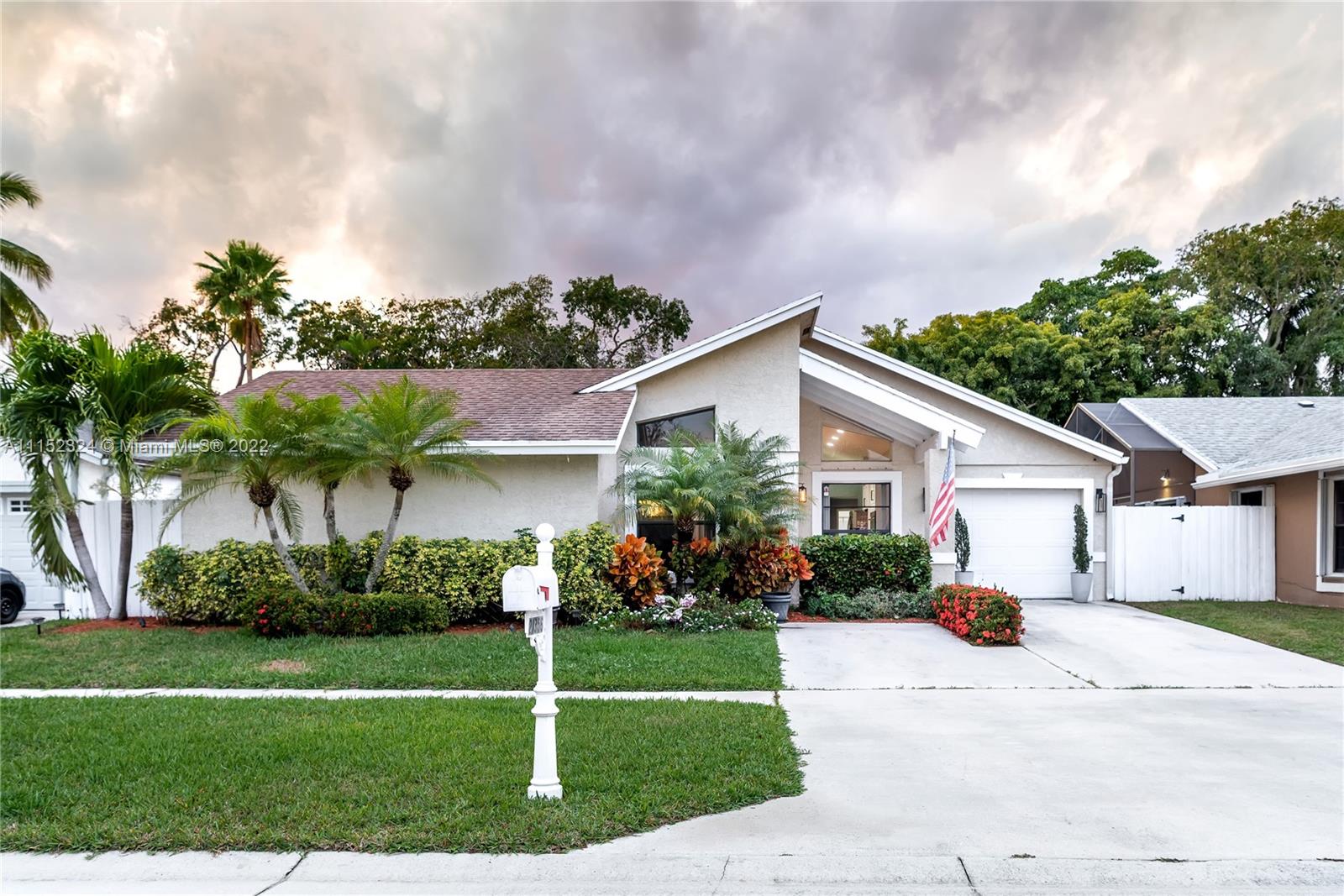 21356 Summertrace Circle Boca Raton, FL 33428 - Photo 1 of 21 a view of a white house next to a yard with potted plants and large trees