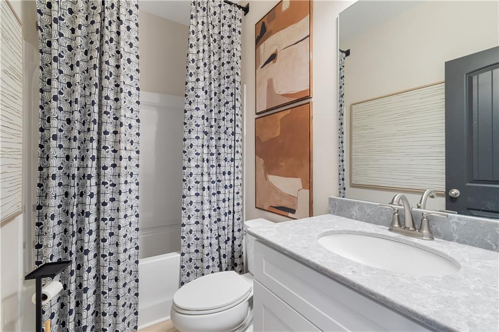 204 Daybreak Lane Newnan, GA 30265 - Photo 9 of 48 a bathroom with a granite countertop toilet a sink and a mirror