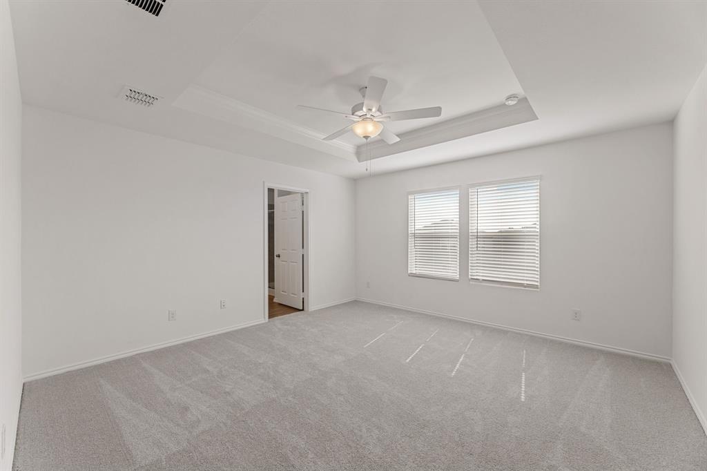 816 Breakwater Drive Princeton, TX 75407 - Photo 16 of 30 an empty room with chandelier fan and windows