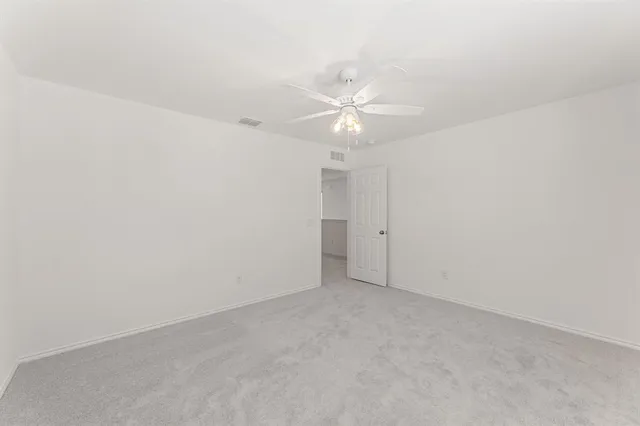 an empty room with a ceiling fan and a fan