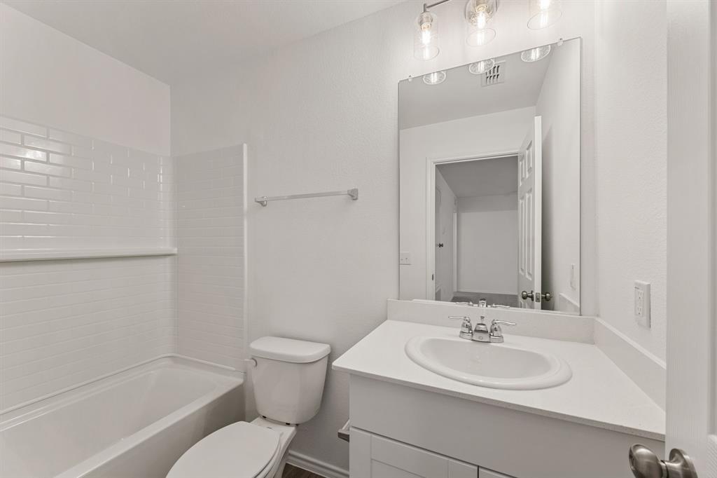 816 Breakwater Drive Princeton, TX 75407 - Photo 27 of 30 a bathroom with a toilet a sink and a bathtub