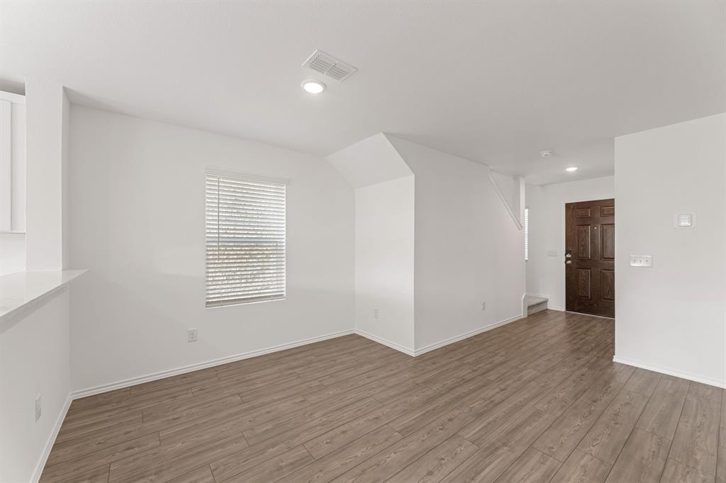 816 Breakwater Drive Princeton, TX 75407 - Photo 4 of 30 a view of an empty room with wooden floor and a window