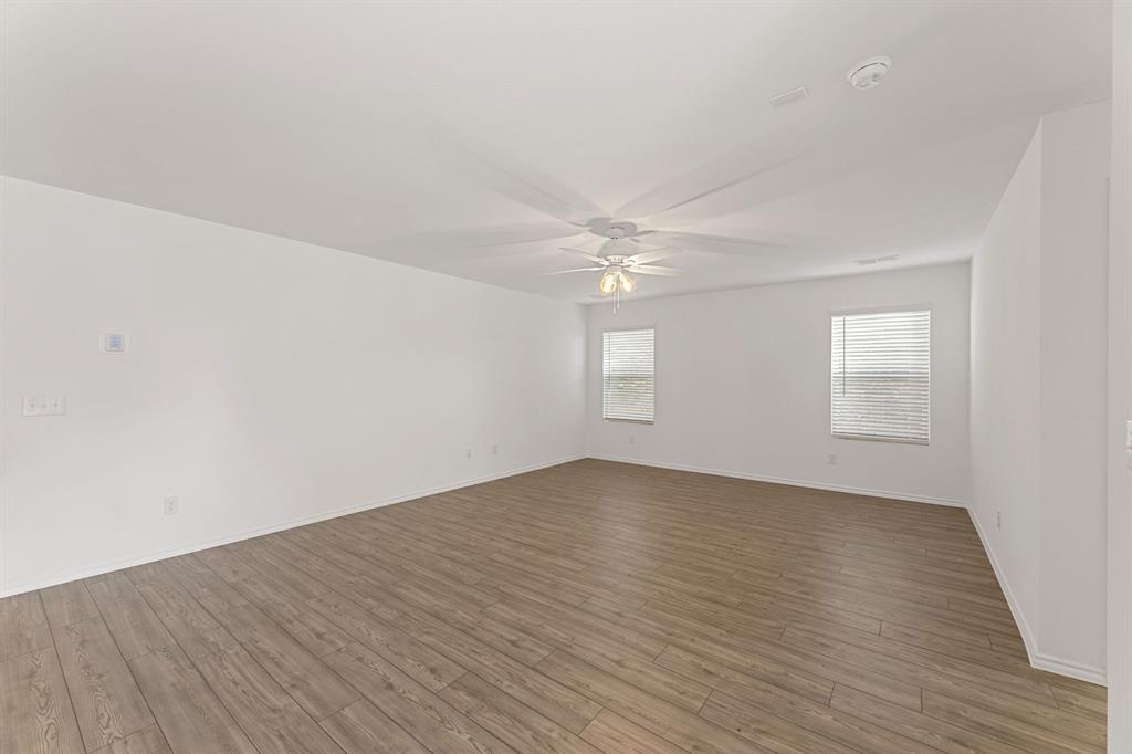 816 Breakwater Drive Princeton, TX 75407 - Photo 5 of 30 a view of an empty room with wooden floor and a window