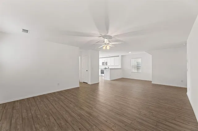 a view of a room with wooden floor and a ceiling fan