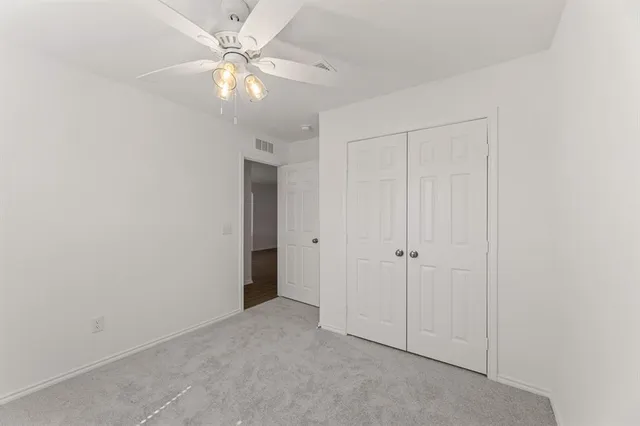 an empty room with fan and a ceiling fan