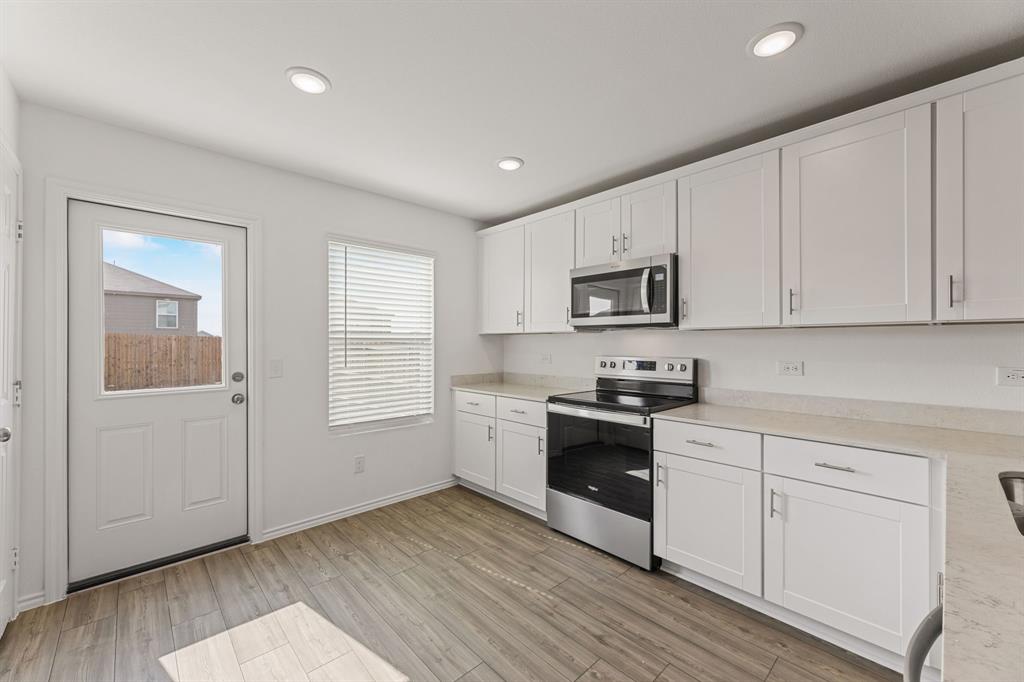 816 Breakwater Drive Princeton, TX 75407 - Photo 10 of 30 a kitchen with granite countertop white cabinets and stainless steel appliances