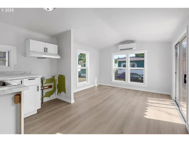 a view of a kitchen with fridge and wooden floor