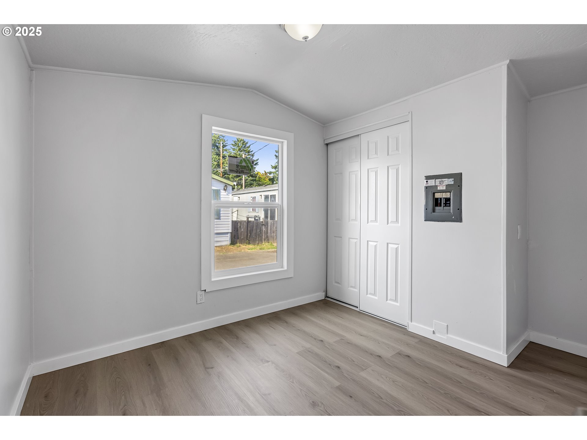 12726 Southeast Division Street, Unit 17 Portland, OR 97236 - Photo 22 of 26 a view of an empty room with wooden floor and a window