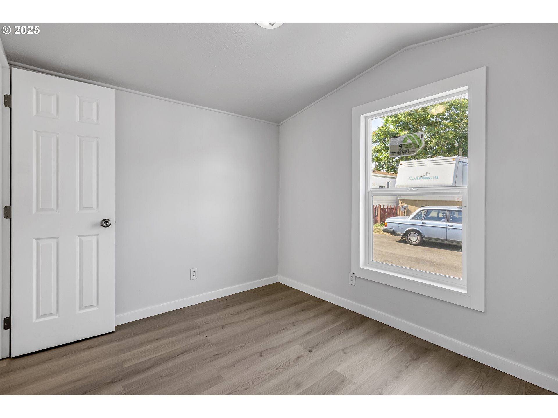 12726 Southeast Division Street, Unit 17 Portland, OR 97236 - Photo 23 of 26 a view of an empty room with wooden floor and a window