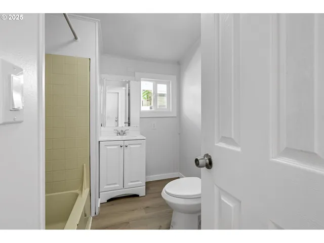 a bathroom with a toilet a sink a mirror and vanity