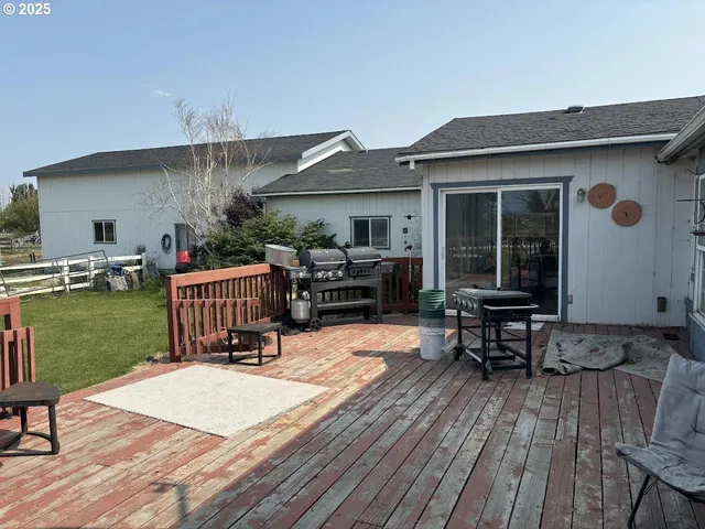 a roof deck with table and chairs potted plants with wooden floor