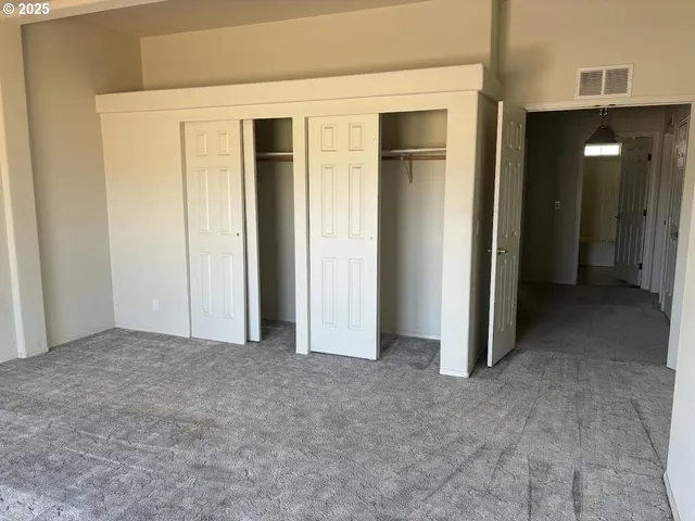 an empty room with closet and a bathroom