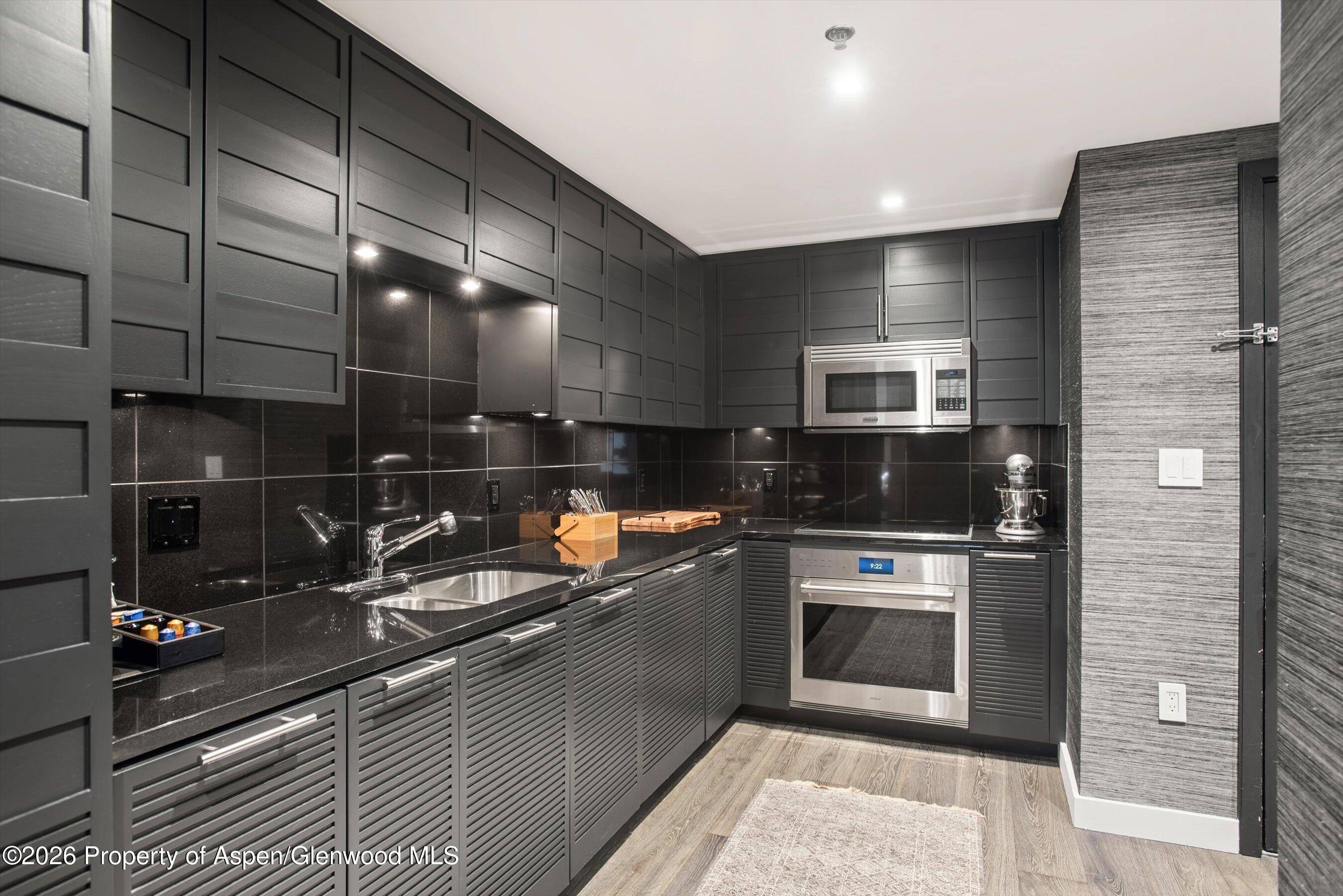 130 Wood Road, Unit 532 Snowmass Village, CO 81615 - Photo 6 of 15 a kitchen with stainless steel appliances kitchen island granite countertop a sink and cabinets