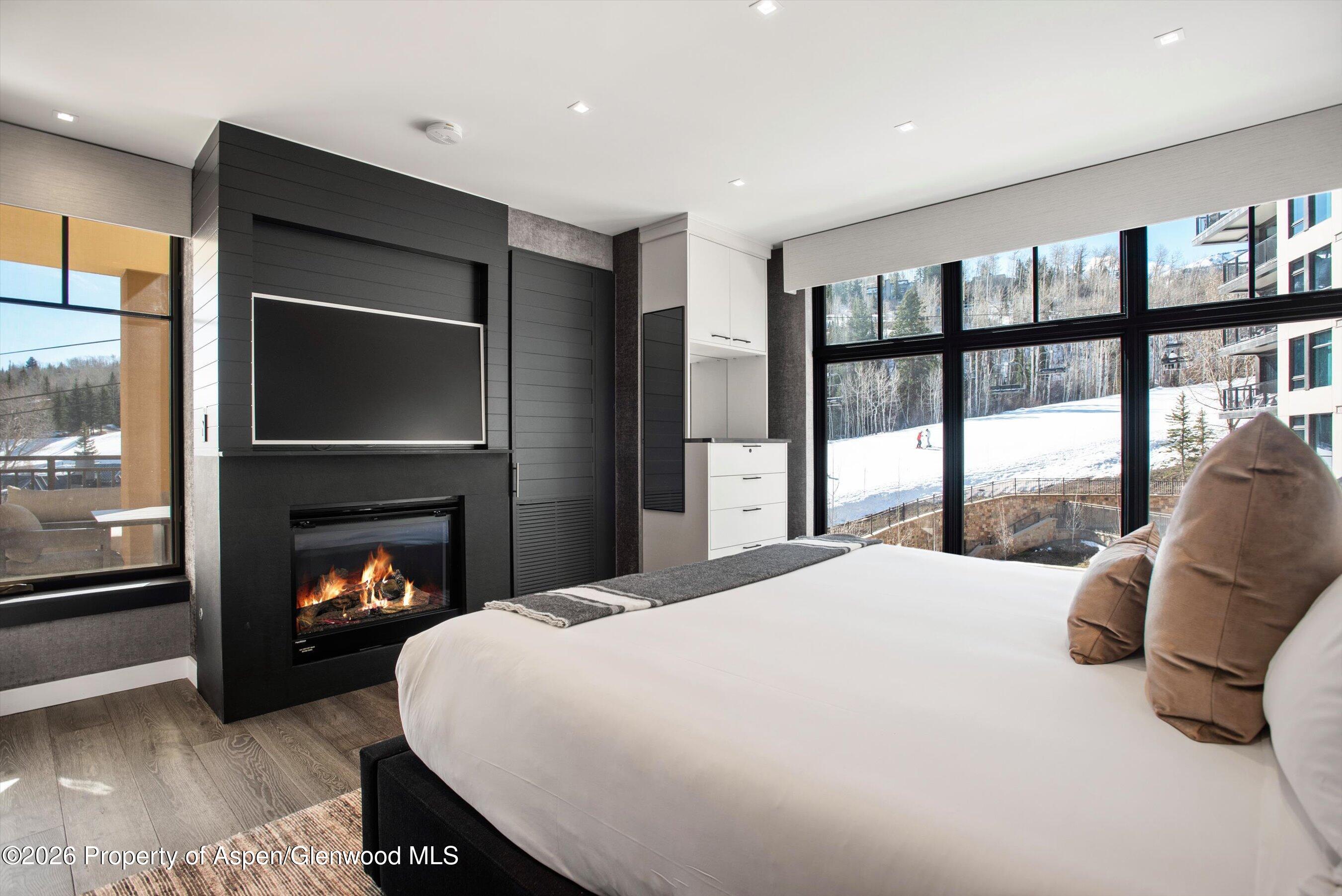 130 Wood Road, Unit 532 Snowmass Village, CO 81615 - Photo 8 of 15 a bedroom with a bed and a fireplace