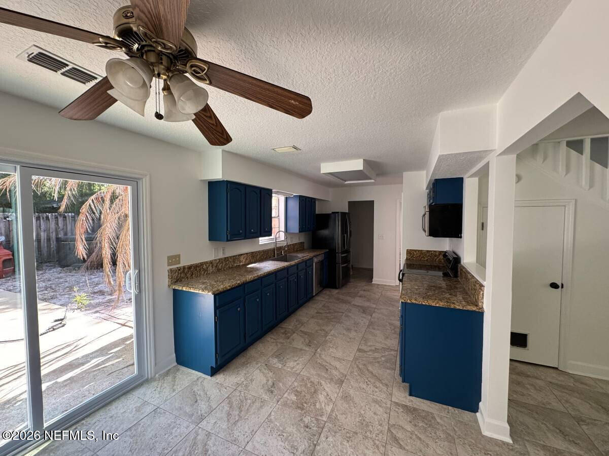 543 Ray Edwards Road St. Augustine, FL 32086 - Photo 4 of 19 a kitchen with granite countertop a refrigerator and a sink