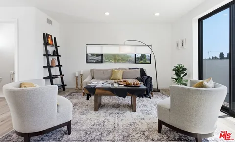 a living room with furniture a rug and white walls