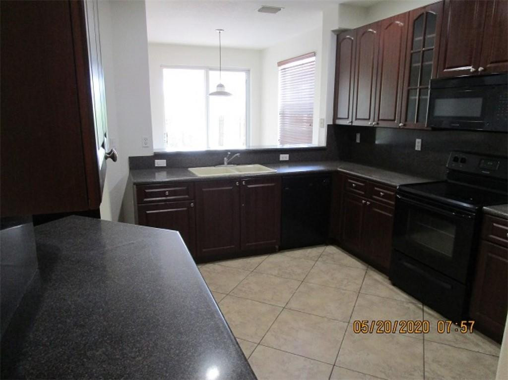1734 Southwest 151 Place Miami, FL 33185 - Photo 3 of 12 a kitchen with a sink a stove and cabinets