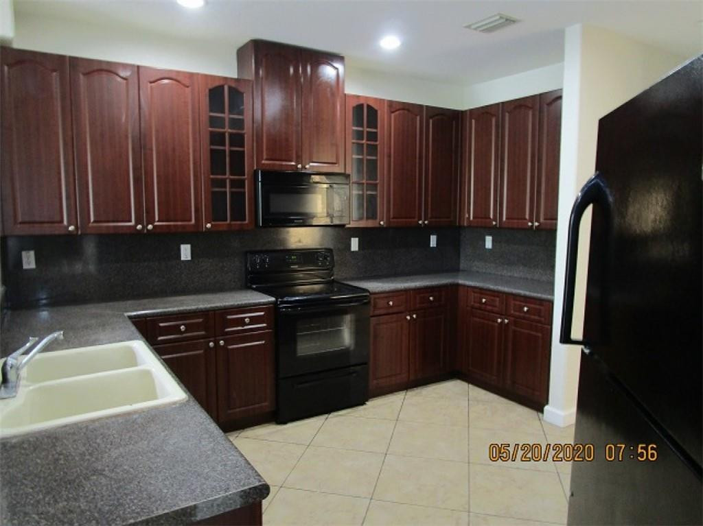 1734 Southwest 151 Place Miami, FL 33185 - Photo 4 of 12 a kitchen with stainless steel appliances granite countertop a refrigerator and a stove