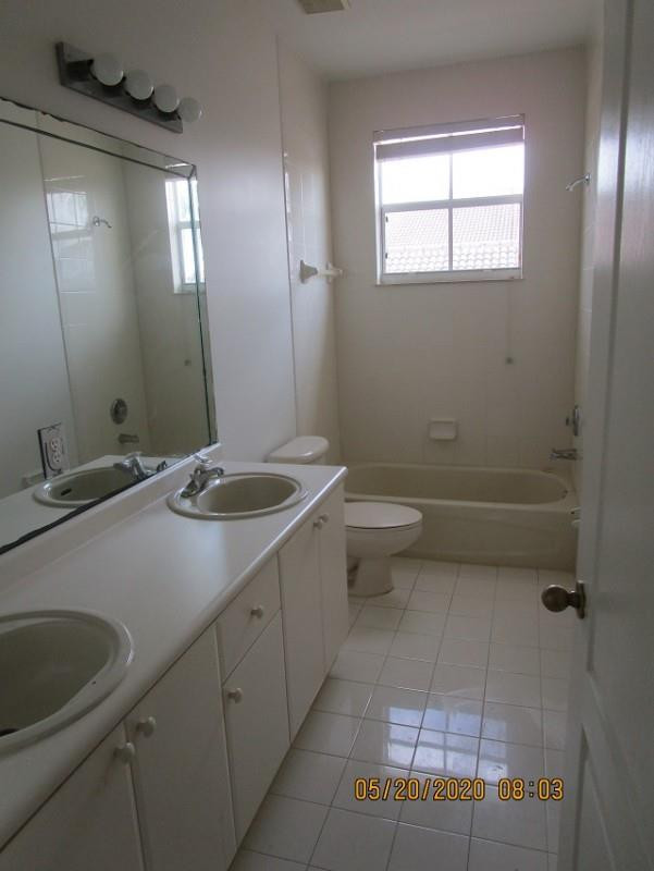 1734 Southwest 151 Place Miami, FL 33185 - Photo 8 of 12 a bathroom with a sink a toilet and a mirror