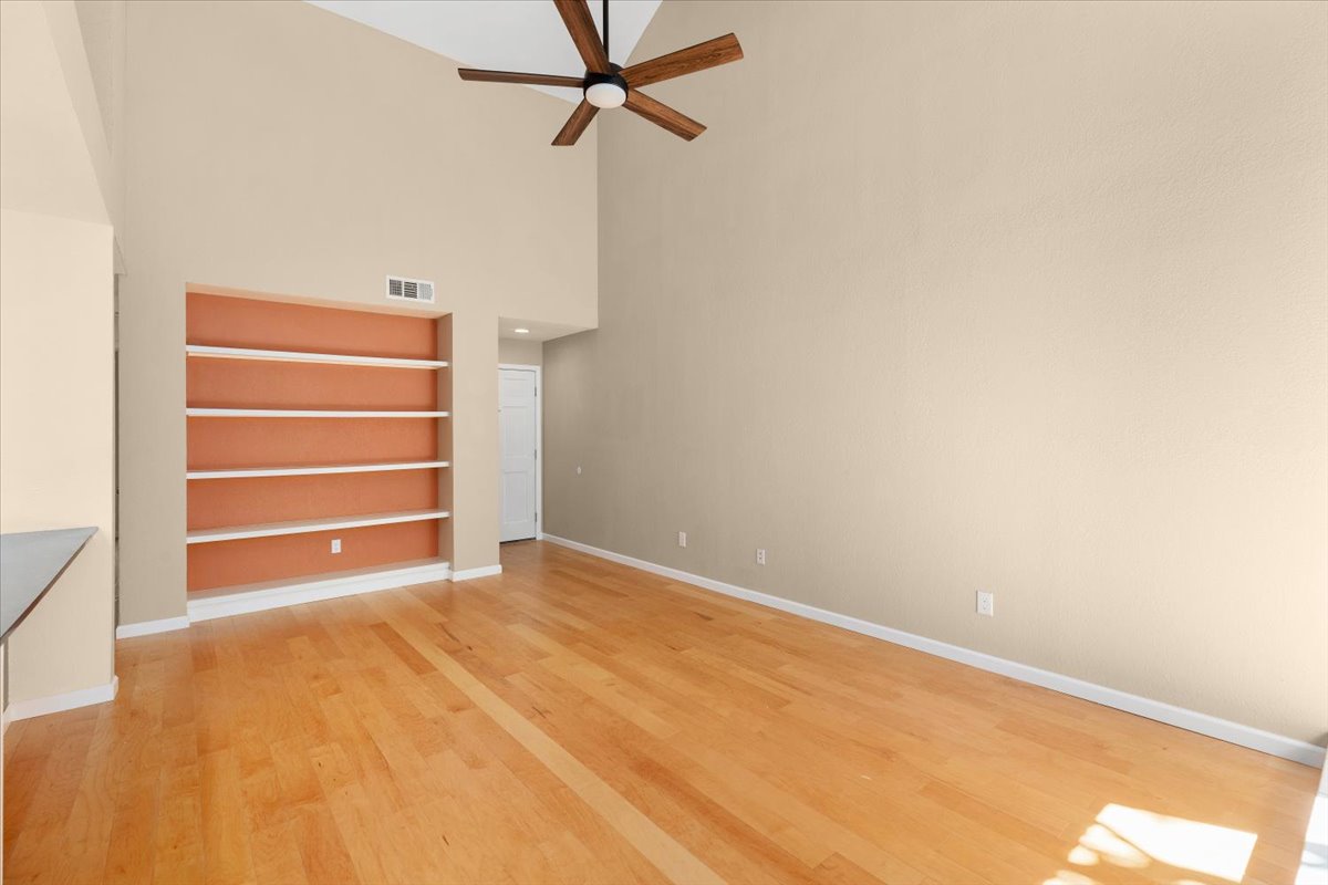 4711 Spicewood Springs Road, Unit 4222 Austin, TX 78759 - Photo 10 of 35 Hardwood floors and built-in shelving complement this spacious living area with soaring ceilings.