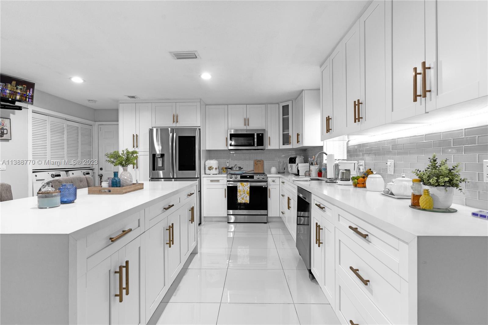 12458 Southwest 220th Street Miami, FL 33170 - Photo 11 of 25 a kitchen with a sink dishwasher stove and cabinets