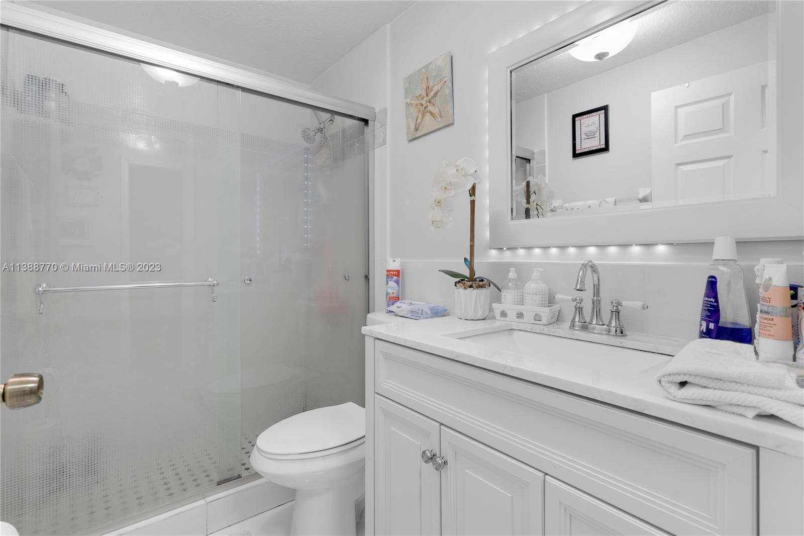 12458 Southwest 220th Street Miami, FL 33170 - Photo 14 of 25 a bathroom with a sink toilet vanity and shower