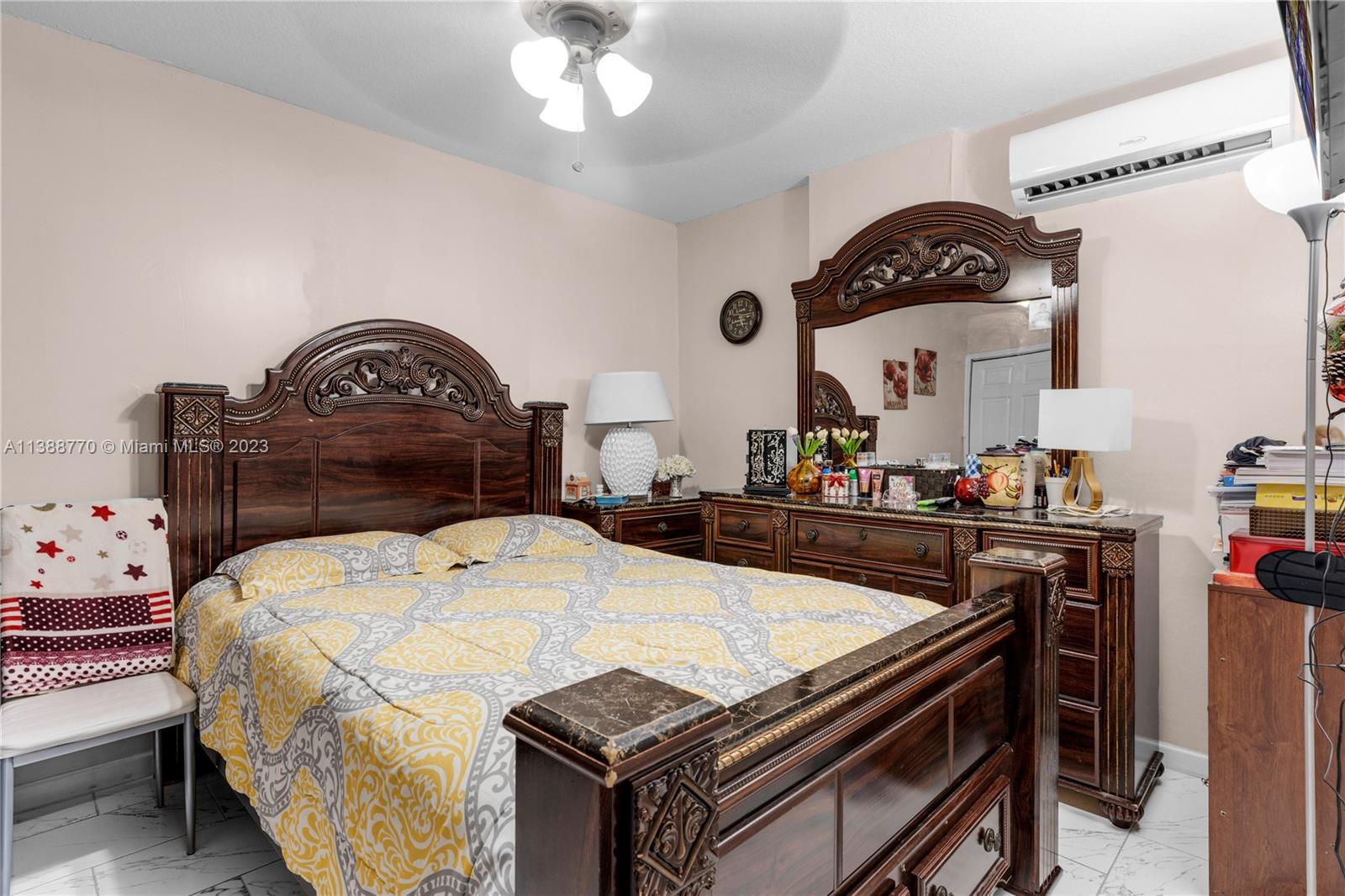 12458 Southwest 220th Street Miami, FL 33170 - Photo 17 of 25 a bedroom with a bed and a chandelier