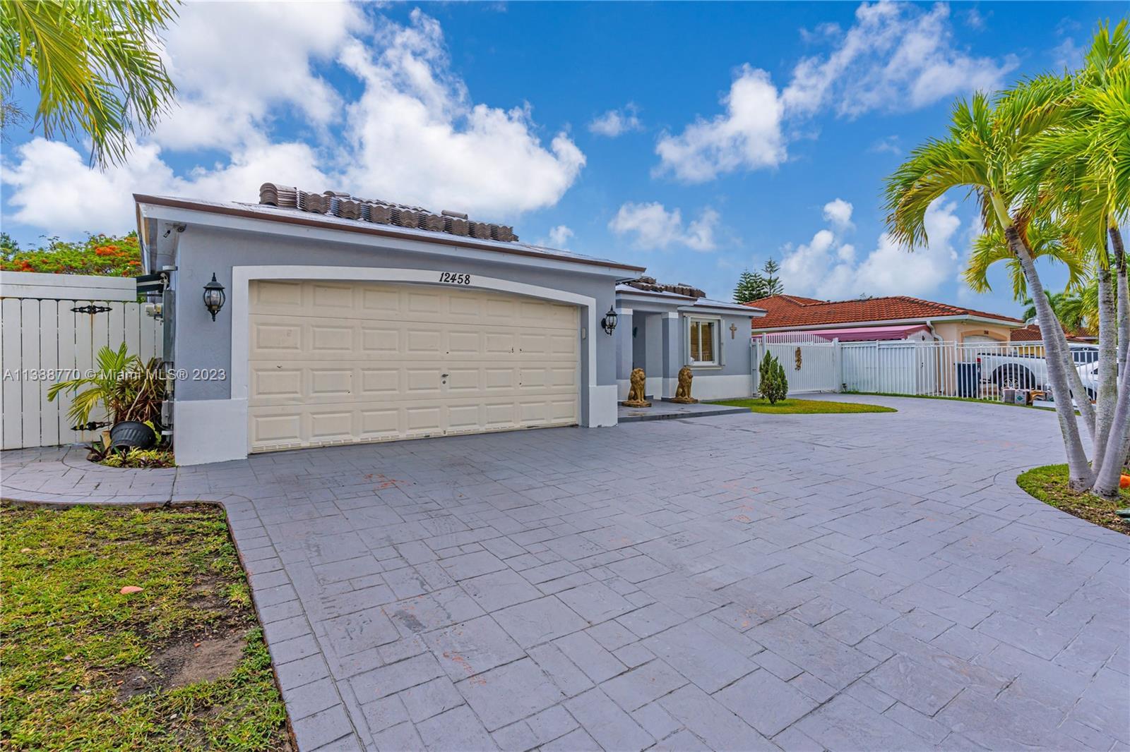 12458 Southwest 220th Street Miami, FL 33170 - Photo 2 of 25 a front view of a house with a yard and garage