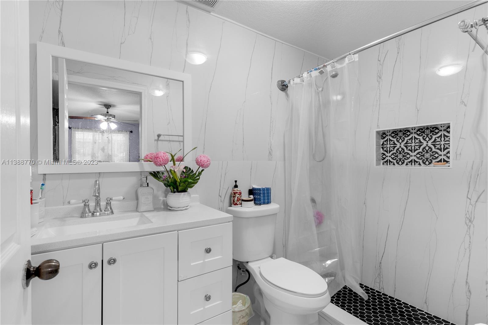 12458 Southwest 220th Street Miami, FL 33170 - Photo 21 of 25 a bathroom with a sink a toilet a mirror and shower