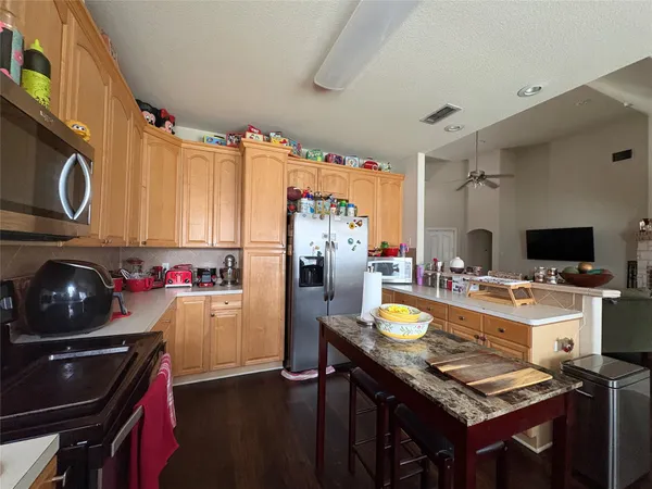 a kitchen with refrigerator and stove top oven