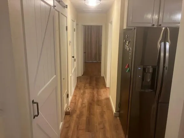 a view of a hallway with wooden floor