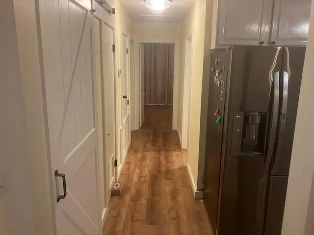 a view of a hallway with wooden floor