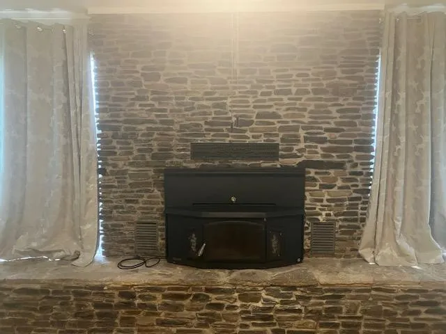 a view of empty room with wooden floor and fireplace