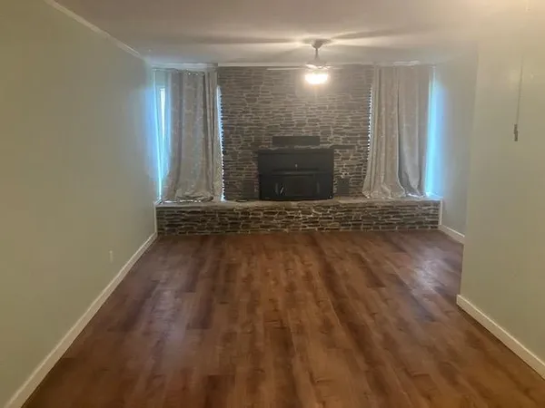 a view of an empty room with wooden floor