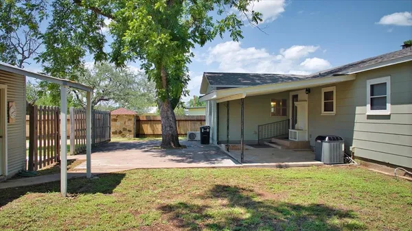 a view of a house with backyard and tree