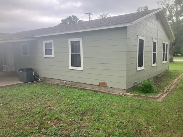 a view of a backyard with plants and a bench